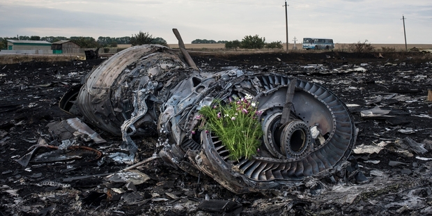 Flowers have been placed on one of the Boeing's mangled engines near the village of Grabovo. Photo / AP