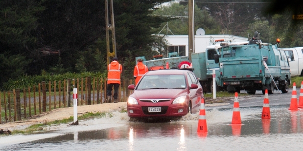 A car drives through surface flooding on Waimarama Rd yesterday afternoon. One lane of the road remained open. Photo / Warren Buckland