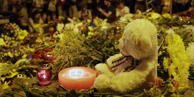 Candles and flowers are left for the victims of the Malaysia Airlines flight MH17 at Netherlands Embassy in Kiev. Photo / Getty