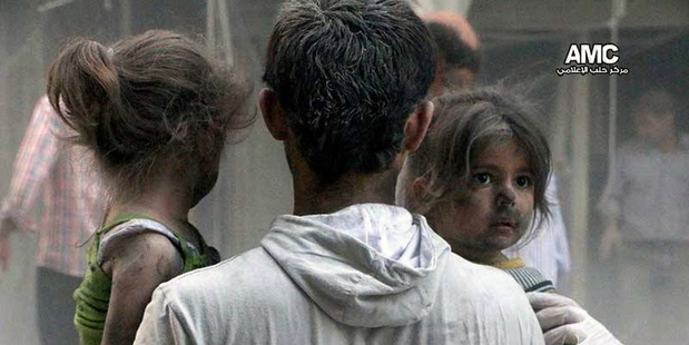 A family in Aleppo after an airstrike by Syrian government forces. Photo / AP