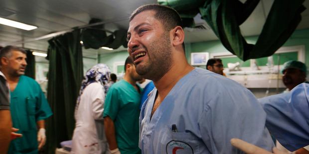 While the Hamas fighters show resilience, a Palestinian medic is overwhelmed by emotion as he takes a break treating wounded people by Israeli strikes. Photo / AP