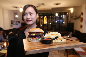 The cheeseburger with Angus beef is served on its signature wooden board. Photo / Getty Images