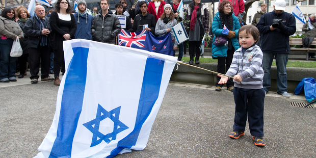 Judah Leung-Wai, aged 2, waves an Israeli flag during a pro-Israel peace rally in Midland Park, Wellington.