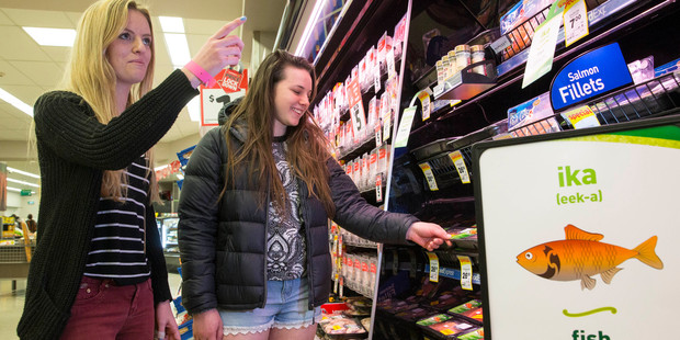 Sonya Burgess (left) and Brooke Merrick study Maori words on display in a Countdown store in central Auckland. Photo / Peter Meecham