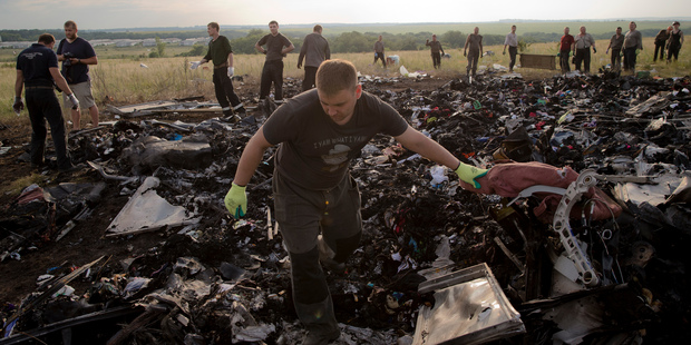 A man looks for the remains of victims in the debris at the crash site of Malaysia Airlines Flight 17 near the village of Hrabove, eastern Ukraine. Photo / AP