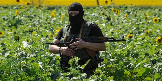 A pro-Russian fighter guards the crash site of Malaysia Airlines Flight 17 near the village of Hrabove, eastern Ukraine. Photo / AP