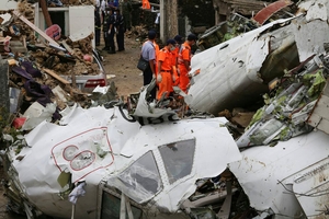 Rescue workers survey the wreckage of TransAsia Airways Flight GE222. Photo / AP