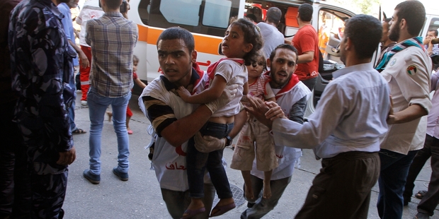 Palestinian medics carry children wounded in a strike on a United Nations school in Beit Hanoun. Photo / AP