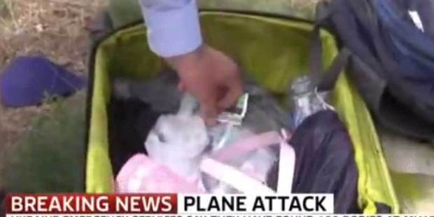 Sky News presenter Colin Brazier reaches into the luggage of a MH17 victim at the crash scene, in a You Tube screen grab.