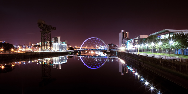 Glasgow's 'Squinty Bridge' and buildings alongside the River Clyde are illuminated at night. Photo / Thinkstock