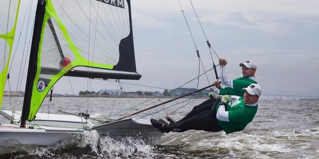 Danish sailors warm up on Guanabara Bay, which has been under scrutiny for pollution levels. Inset, floating waste is gathered. Photo / AP