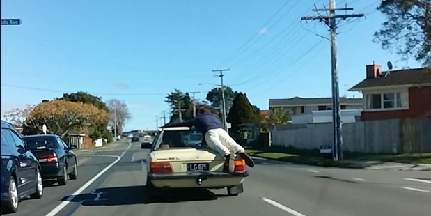 The YouTube clip shows a man clinging to a moving vehicle travelling through the streets of Tauranga. Police said the incident highlights an "obvious lack of regard for personal safety".