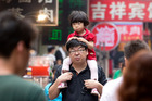 A young girls on her father's shoulders in a market in Xian, China. Photo / Mark Mitchell A young girls on her father's shoulders in a market in Xian, China. Photo / Mark Mitchell