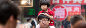 A young girls on her father's shoulders in a market in Xian, China. Photo / Mark Mitchell