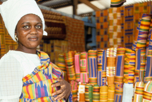 Ghana woman wearing and selling Kente cloth in Accra. Photo / Alamy.