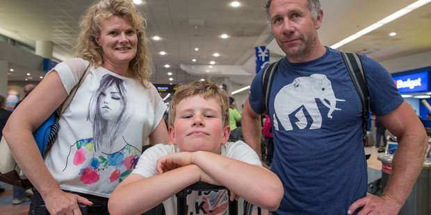 Lianne, Couper (9), and Al Killick from Christchurch, arrive in Auckland after being stuck for four days in Honolulu. Photo / Peter Meecham