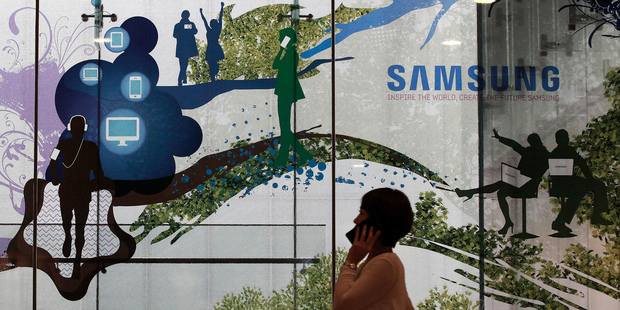 A woman passes by Samsung's showroom in Seoul. Samsung said operating profit fell to a two-year low in the second quarter, as it copes with competition from cheap Chinese smartphones. Photo / AP