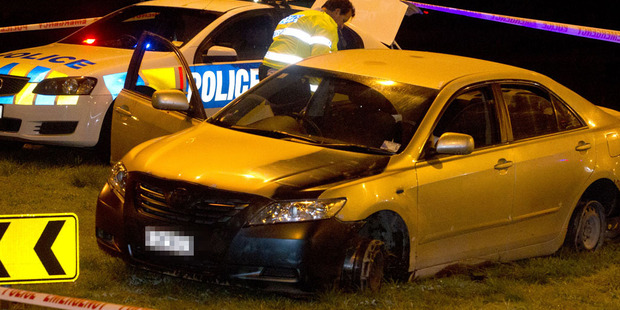 Police inspect the car they were chasing which the offender was driving on its steel rims. Photo / Alan Gibson