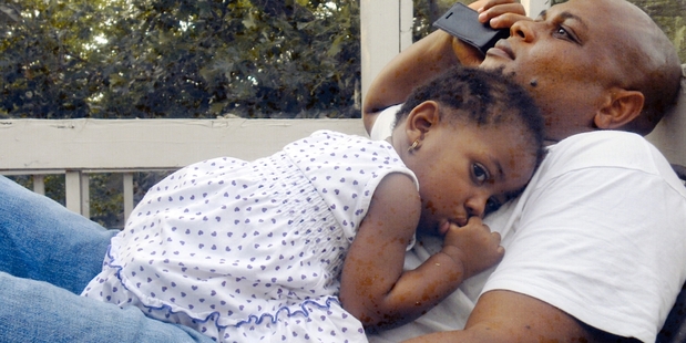 Patrick Sawyer - pictured at home with his granddaughter - died from Ebola after travelling from Liberia to Nigeria. Photo / AP