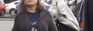 HIDING: Masterton fraudster Fiona Margaret Wilton aka Teal (rear) covers her face with a sweatshirt while one of her friends tries to shield her from the camera as she leaves Masterton District Court. PHOTO/STAFF