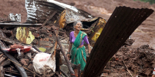 An elderly woman cries as she searches for family members in the India landslide. Photo / AP