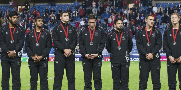 The New Zealand Seven team members stand dejected with their medals after losing to South Africa in the gold medal match. Photo / Greg Bowker