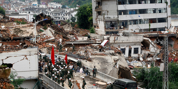 Rescue workers search for survivors amid the remains of collapsed buildings at the epicenter of Sunday's earthquake that struck the town of Longtoushan. Photo / AP