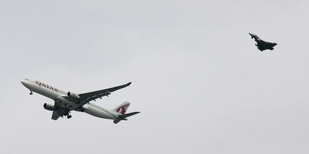 A military fighter jet escorts a passenger jet as it comes in to land at Manchester airport, after a threat was made. Photo / AP