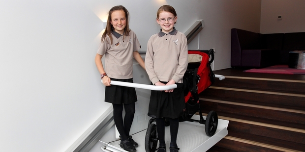 Mission Heights pupils Olivia McSaveney (left) and Hannah Gillespie on the chair lift at Victoria Park Medical Suites in Auckland. Photo / Chris Gorman