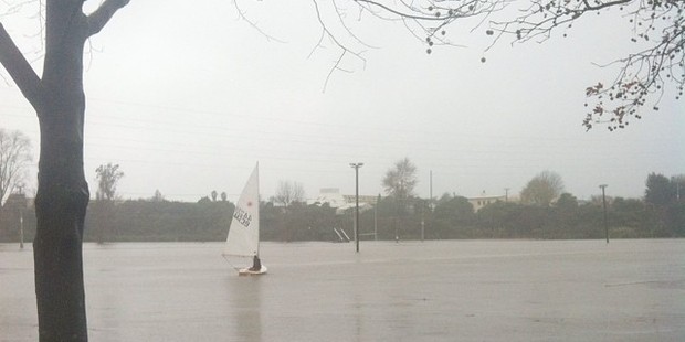 A man sails over flooded rugby fields in Greerton.