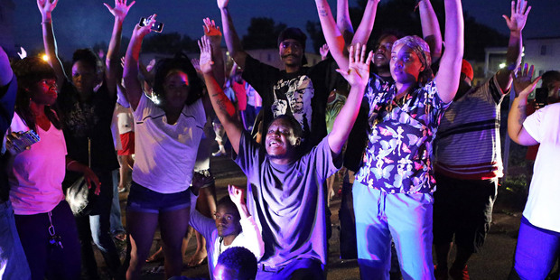 A crowd gathers near the scene where 18-year-old Michael Brown was fatally shot by police in Ferguson. Photo / AP