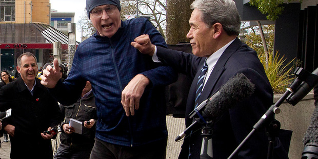 Winston Peters pushes off a heckler outside the Hamilton City Council Building in Garden Place at lunch today Photo / Christine Cornege