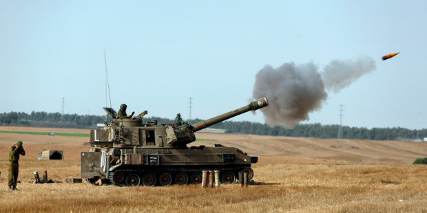 Israeli soldiers fire a shell towards Gaza. The NZ Super Fund says it will retain its investment in an Israeli company that makes white phosphorus - sometimes used in artillery shells. Photo / AP