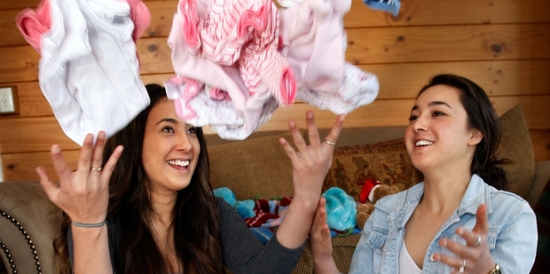 Whangarei sisters Latoya Hood, 19 and Kasey Hood, 16, with some of the baby clothes they have had donated to their Pepi Pride campaign. Photo / Tania Newman