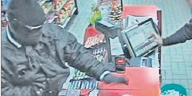 SEEN EARLIER: The closed-circuit footage from Mobil Mart in Taradale Rd shows the robber appearing to be going for a weapon hidden in his top.