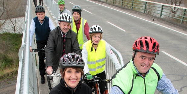 Cynthia Bowers and the regional council's chairman Fenton Wilson cut the tape (appropriately an old cycle tube) to declare the new walk and cycle pathway open. Photo / Warren Buckland