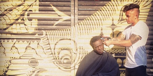 Hair stylist Mark Bustos cuts the hair of a homeless person. Photo / Devin Masga