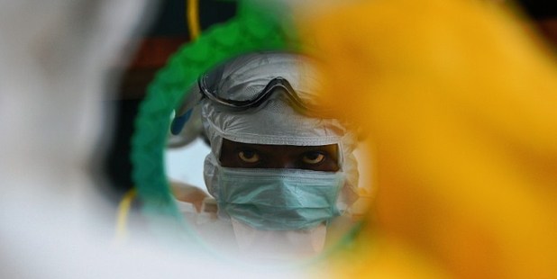 An MSF medical worker checks their protective clothing in a mirror at an MSF facility in Kailahun. Photo / File / AFP