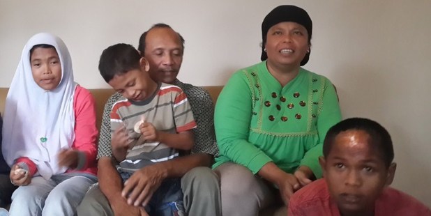 Septi Rangkuti (2nd L) holds his son Jumadi Rangkuti next to his wife Jamaliah (top R), daugther Raudhatul Jannah (L) after being reunited with Arif Pratama Rangkuti (lower R). Photo / AFP
