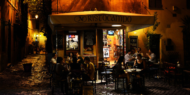 Tourists and locals gather at Trastevere's popular restaurants after dark.