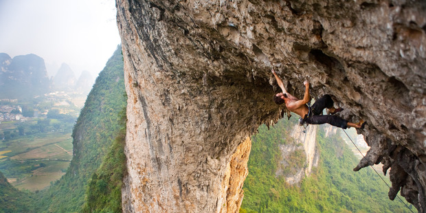 A climber tackles the famous archway of Moon Hill, in China's Yangshuo region. Photo / Derek Cheng