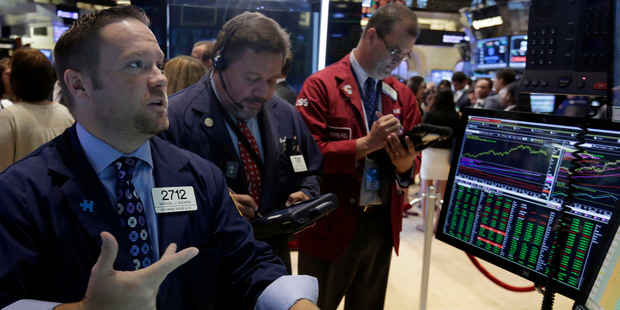 Specialist Michael Shearin, left, works at his post on the floor of the New York Stock Exchange. File photo / AP