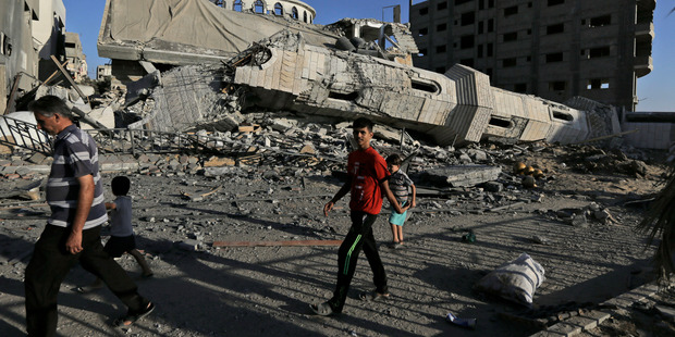 Palestinians walk by the rubble of the toppled minaret of the Abu Jihad Al Wazer mosque, destroyed by an Israeli strike during the war, in Gaza City. Photo / AP