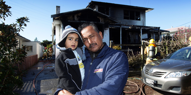 Mohammed Sattar and grandson Mohammed Ariz who live at the property affected by the blaze in Kelston. Photo / Herald on Sunday / Doug Sherring