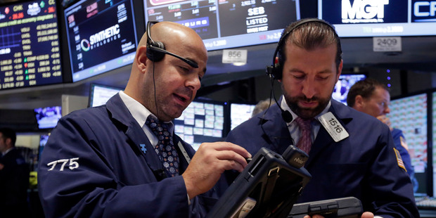Traders Fred DeMarco, left, and Greg Mulligan confer on the floor of the New York Stock Exchange. File photo / AP