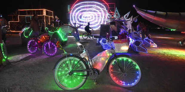 A Burning Man participant's bike is surrounded by art cars that are lined up at the Black Rock DMV to be registered at Burning Man. Photo / AP