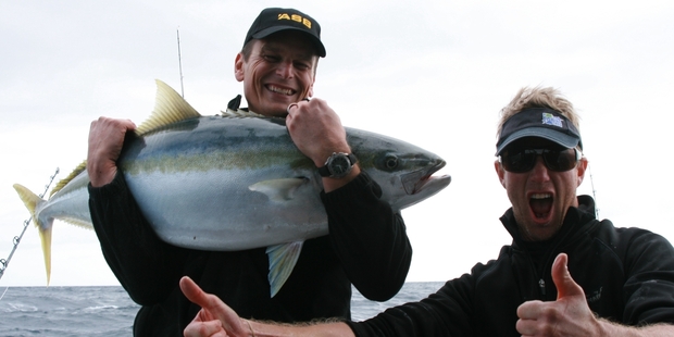 Team NZ skipper Dean Barker with his catch and an enthusiastic Matt Watson.