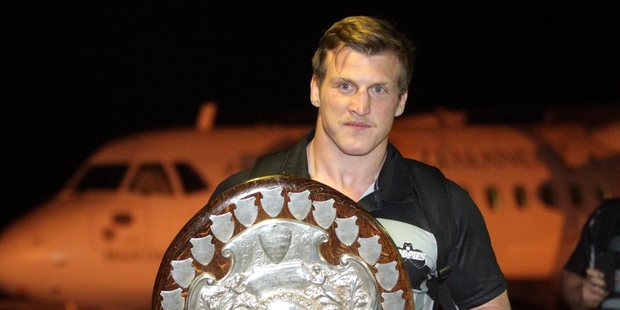 To a huge cheer Magpies captain Brendon O'Connor was first into the airport terminal - carrying a very special piece of luggage. Photo / Paul Taylor