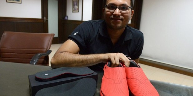LeChal co-founder Krispian Lawrence with a pair of the red smart sneakers.
Photo / AFP