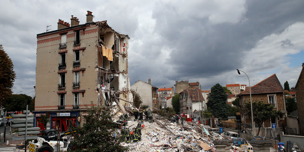 French firemen search in the rubble of a building after an explosion collapsed it, in Rosny-sous-Bois, outside Paris. Photo / AP